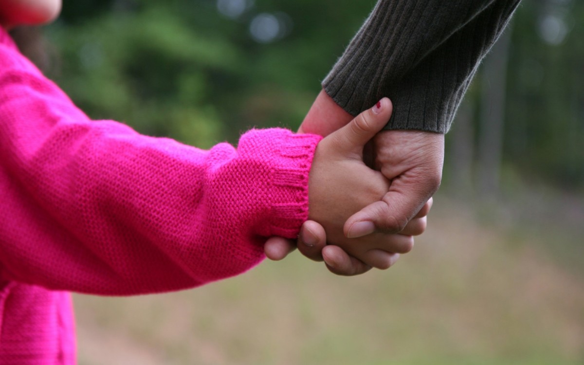 childs hand holding an adult hand